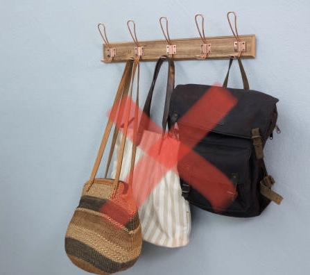 Various Bags Hanging On Hook Against Wall